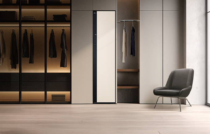 모던한 베이지 톤 드레스룸 중앙에 설치된 LG 스타일러와 주변 가구 및 의자가 어우러진 인테리어 연출 이미지.